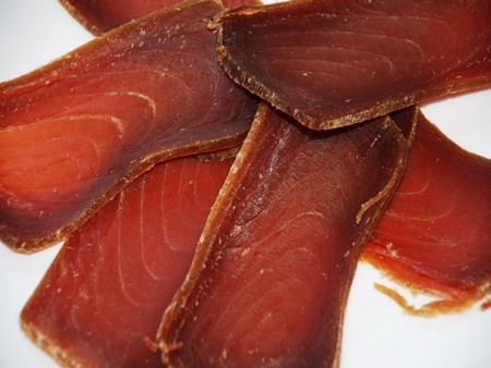 En un plato blanco se disponen rodajas finas de mojama de atún.